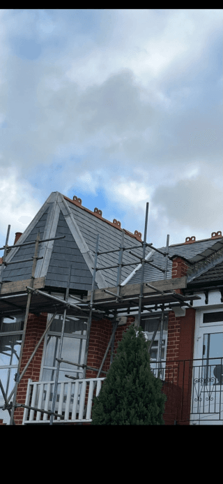Slate roof replacement in progress with scaffolding