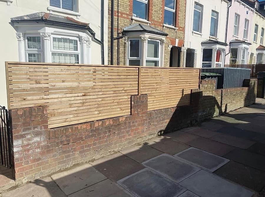 Horizontal slatted fence with brick base